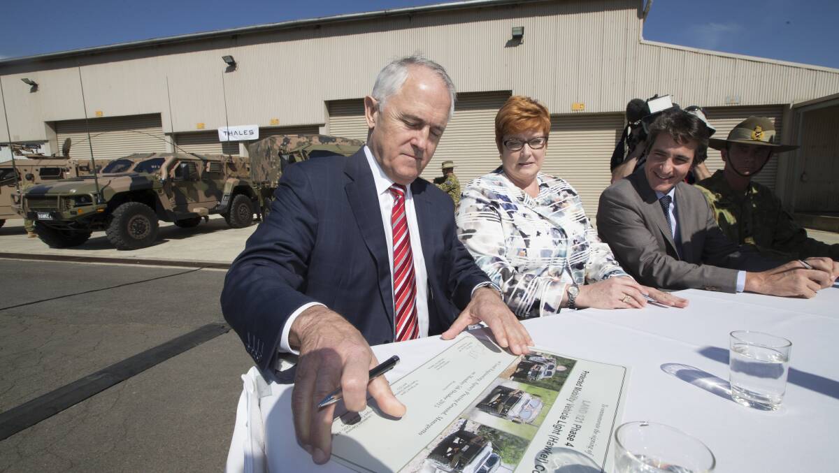 SIGNING OFF: Prime Minister Malcolm Turnbull and Defence Minister Marise Payne sign a $1.3 billion contract for Bendigo's Thales Australia to build 1100 Hawkei vehicles.