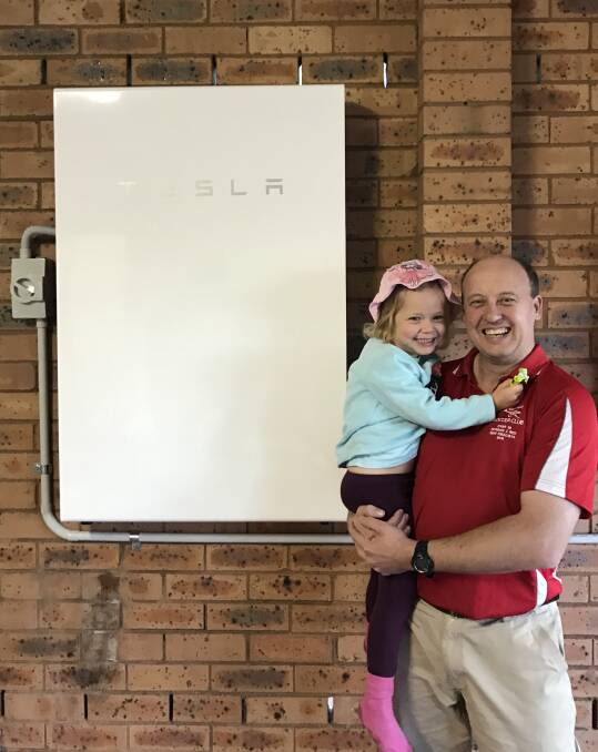 Michael D'Angelo, in front of the Tesla PowerWall, wanted to 'harness the technology we have available at the moment to take control back into our own hands'.