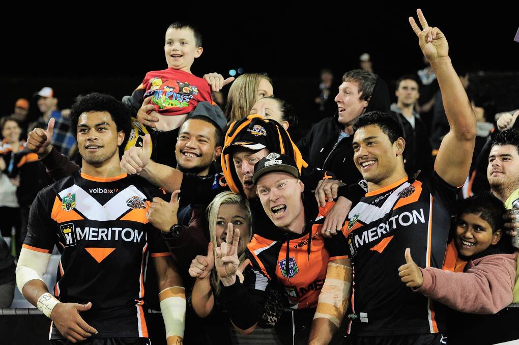 Sitaleki Akauola of the Tigers (L) and David Nofoaluma of the Tigers (R) celebrate with fans after victory during the round 6 NRL match between the Wests Tigers and the North Queensland Cowboys. Picture: Brett Hemmings/Getty Images