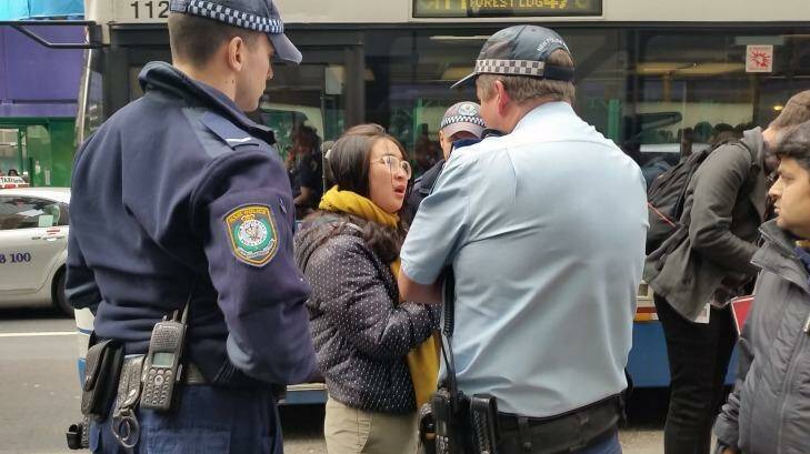 Police question a young woman outside the Sydney Apple Store. Photo: Hannah Francis