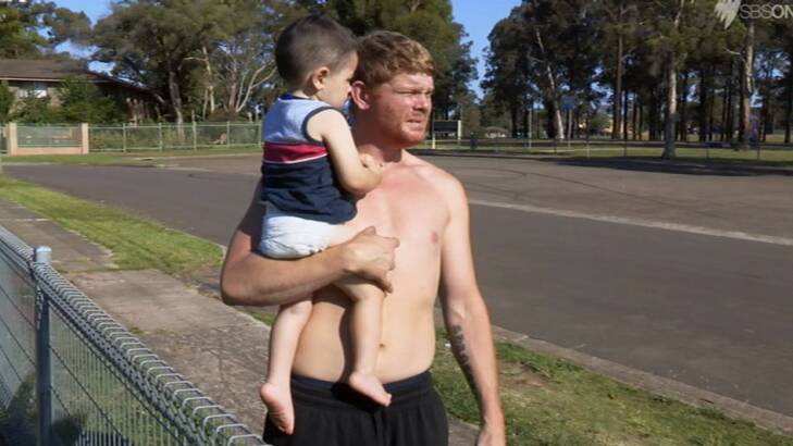 Corey holds his two-year-old son in season one of <i>Struggle Street</i>. Photo: SBS