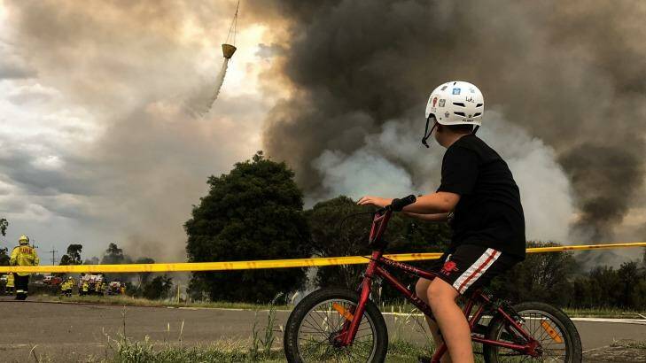 Luke, aged 11, watches the fires as they burn near his home. Photo: Marina Neil