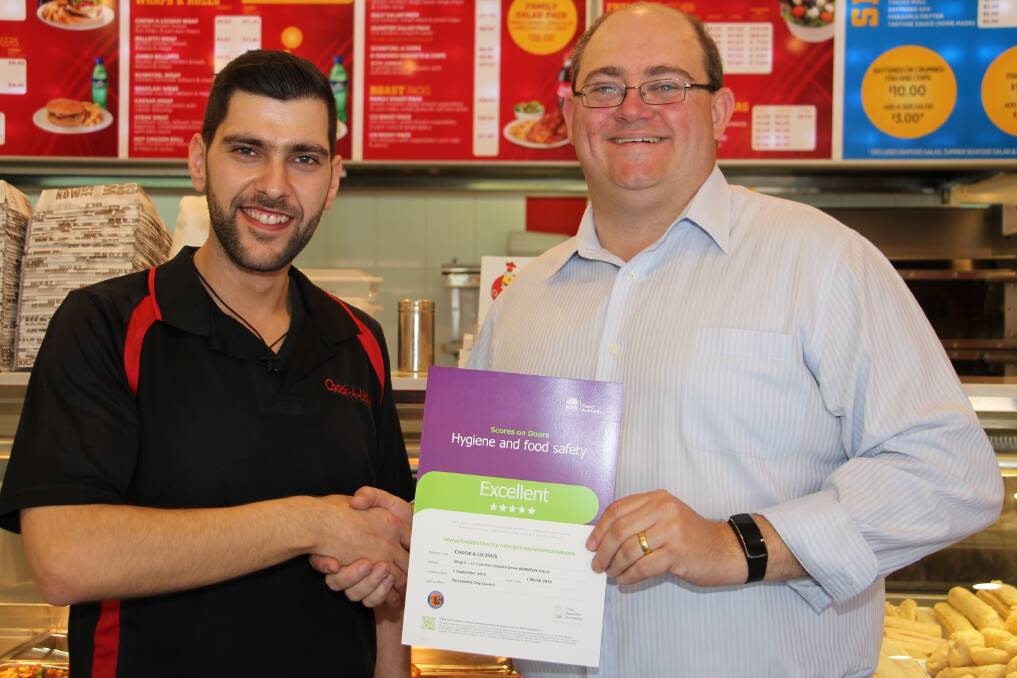 Top shop: Theo Asarloglou (left), of Chook-a-licious, gets his five-star Scores on Doors certificate from Parramatta's then-mayor Scott Lloyd. Theo displays the certificate proudly in two locations in the store.