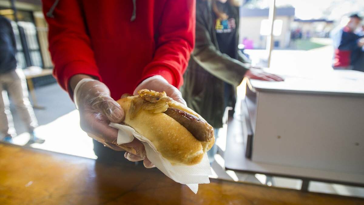 The sausage on bread roll served to voters at polling stations has become a modern Australian tradition on election day. Picture: Dion Georgopoulos