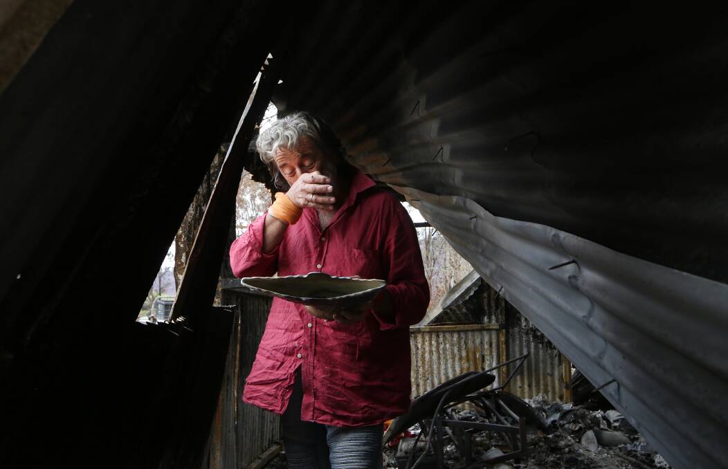 Mark Canaider examines one of dozens of ceramic pieces in the ruins of his shed near Wyndham.
