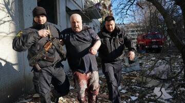 Ukrainian security forces accompany a wounded man after an airstrike hit an apartment complex in Chuhuiv, Kharkiv Oblast, Ukraine. Picture: Getty Images