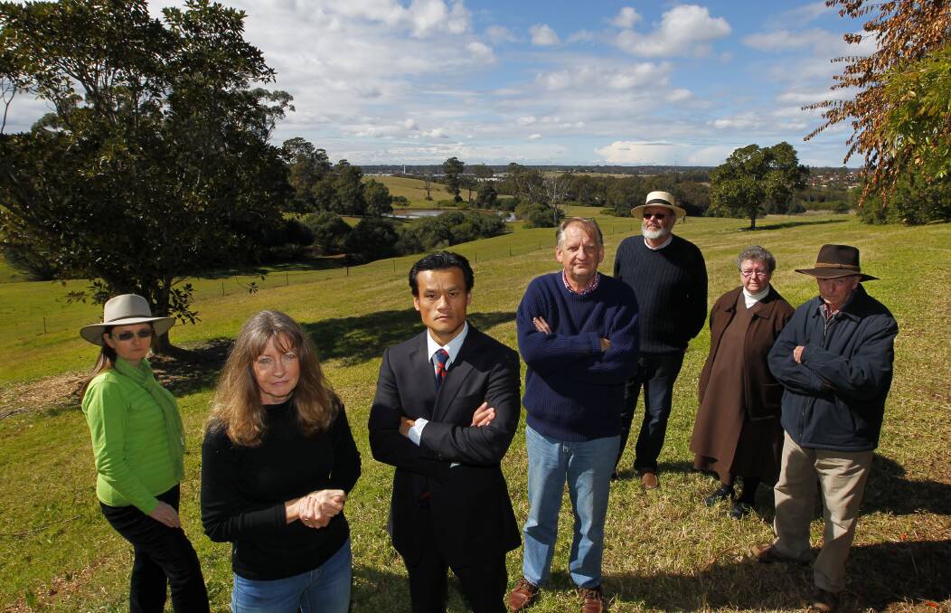 Unsure: Residents against the proposed 136,000-plot cemetery in the Scenic Hills, including Jacqui Kirkby and MP Anoulack Chanthivong (second and third from left) met at Ms Kirkby's property on Friday. Picture: Anna Warr