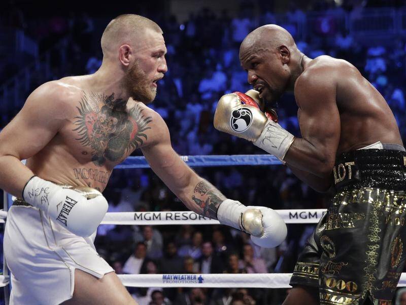 Retired boxing champion Floyd Mayweather Jnr (R) says he will step back into the ring in 2020.
