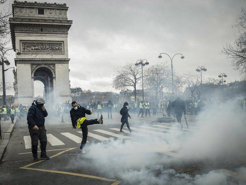 Riot police have unleashed tear gas and sprayed water cannons at yellow-vest protesters in Paris.