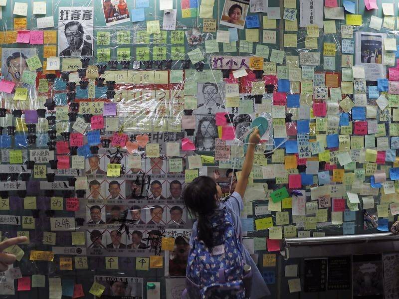 Pro-Beijing supporters have begun tearing down protest walls of colourful notes in Hong Kong.